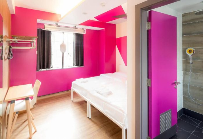 Generator London gay-friendly hotel room. Bright pink walls, bed, desk, and shower room. Pet-friendly hostel for gay men in London.