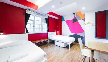 Generator London gay-friendly hotel room. Two beds, desk, colorful wall art. Pet-friendly lodging option for gay travelers in London.