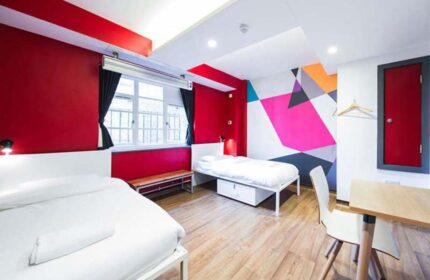 Generator London gay-friendly hotel room. Two beds, desk, colorful wall art. Pet-friendly lodging option for gay travelers in London.