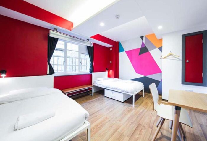 Generator London gay-friendly hotel room. Two beds, desk, colorful wall art. Pet-friendly lodging option for gay travelers in London.
