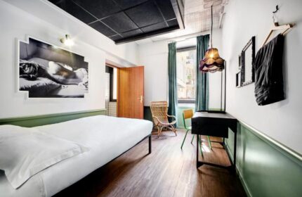 Generator Rome gay-friendly hotel room. Modern design, featuring a bed, desk, and stylish decor. Perfect for gay travelers seeking comfort.