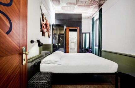 Generator Rome gay-friendly hotel: a stylish room with a double bed, modern decor, and a bathroom view. Perfect for gay travelers in Rome.