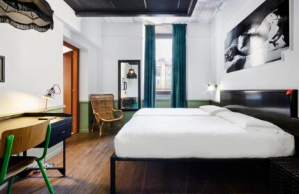 Gay-friendly hotel Generator Rome room. Twin beds, desk, chair, and artwork. A comfortable and stylish space for gay travelers in Rome.