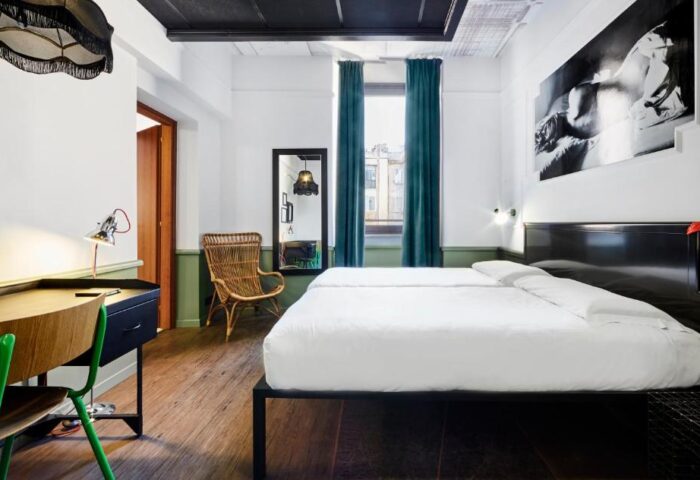 Gay-friendly hotel Generator Rome room. Twin beds, desk, chair, and artwork. A comfortable and stylish space for gay travelers in Rome.