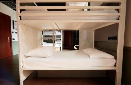 Generator Rome, gay-friendly hotel: Bunk beds in a dorm room. White metal frame, clean linens, and a modern, minimalist design. Budget-friendly stay in Rome.