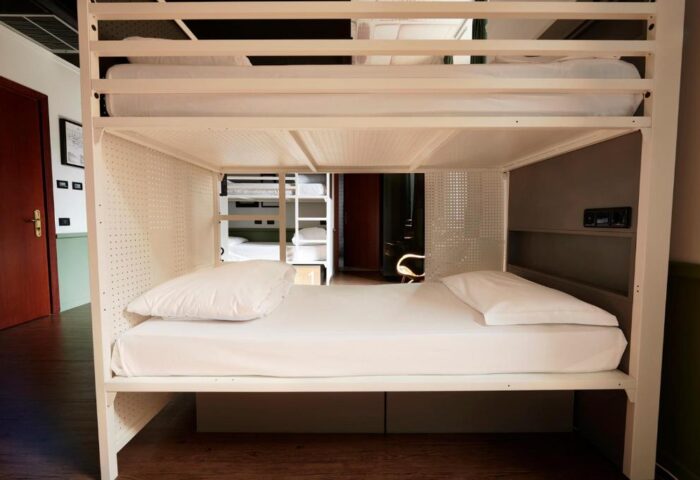 Generator Rome, gay-friendly hotel: Bunk beds in a dorm room. White metal frame, clean linens, and a modern, minimalist design. Budget-friendly stay in Rome.