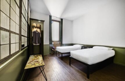 Generator Rome gay-friendly hotel room. Twin beds with white linens, wardrobe, and window. A stylish, comfortable space for gay travelers.