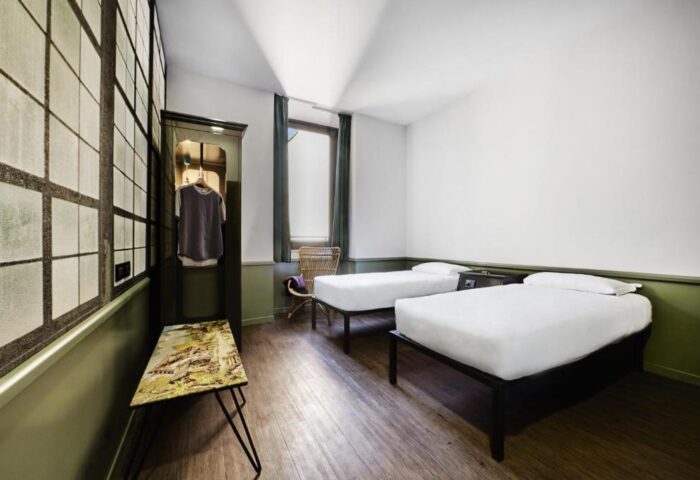 Generator Rome gay-friendly hotel room. Twin beds with white linens, wardrobe, and window. A stylish, comfortable space for gay travelers.