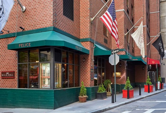 Gild Hall, A Thompson Hotel By Hyatt facade. Gay-friendly hotel with Felice restaurant. Flags, including the US flag, fly outside.