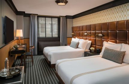 Gild Hall, A Thompson Hotel By Hyatt room. Two beds, leather headboard. Gay-friendly hotel for gay men travel.