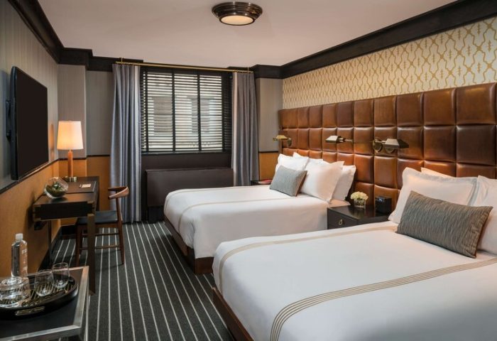 Gild Hall, A Thompson Hotel By Hyatt room. Two beds, leather headboard. Gay-friendly hotel for gay men travel.