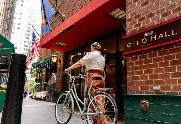 Gild Hall, A Thompson Hotel by Hyatt entrance. Woman with bike. Gay-friendly hotel in NYC, near Financial District. Travel advice for gay men.