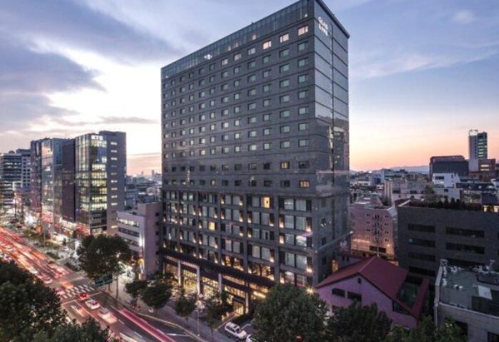 Glad Live Gangnam hotel exterior. Gay-friendly hotel in Seoul's Gangnam district. Modern building with city view at dusk.