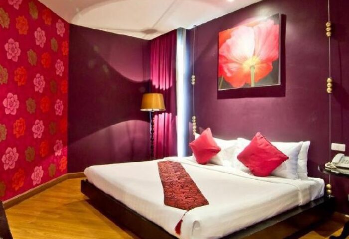 Glitz Hotel gay-friendly room. Modern design with red accents, flower art, and a king-size bed. Perfect for gay travel and a comfortable stay.