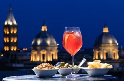 Golden Tulip Rome Piram gay-friendly hotel rooftop aperitivo at night. Drinks and snacks with a view of the city. Rome gay travel.
