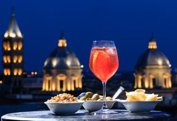 Golden Tulip Rome Piram gay-friendly hotel rooftop aperitivo at night. Drinks and snacks with a view of the city. Rome gay travel.
