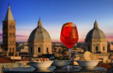 Golden Tulip Rome Piram gay-friendly hotel rooftop bar. Aperol spritz, snacks, and Rome skyline view. Gay travel in Rome.