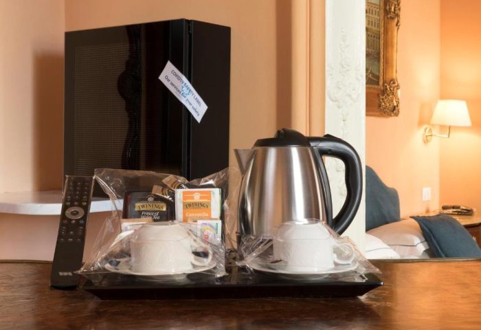 Golden Tulip Rome Piram hotel room detail: kettle, tea, cups, remote on a tray. Gay-friendly hotel amenities for a comfortable stay in Rome.