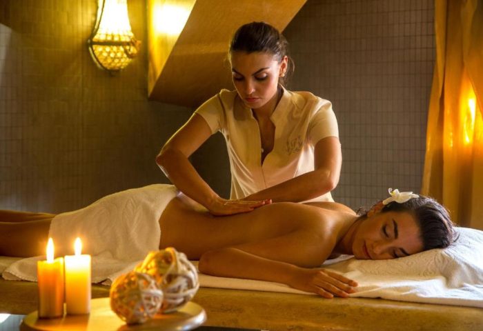 Golden Tulip Rome Piram gay-friendly hotel: Woman receiving a back massage at the spa. Candles create a relaxing atmosphere.