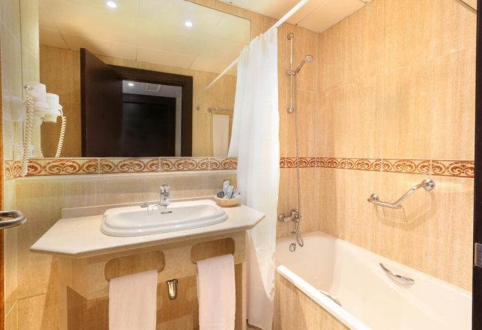 Bathroom at Gran Hotel Cervantes by Blue Sea, a gay-friendly hotel. Sink, mirror, bathtub, shower, and towels. Great for gay travel.