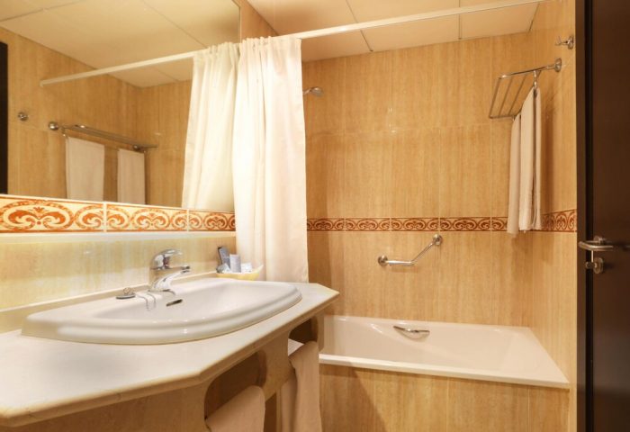 Bathroom at Gran Hotel Cervantes by Blue Sea, a gay-friendly hotel. Sink, bathtub, and shower curtain visible. Ideal for gay travel.