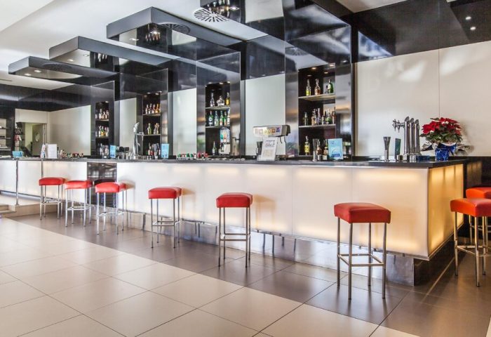 Gran Hotel Cervantes by Blue Sea bar area. Gay-friendly hotel bar with red stools. Great spot to meet fellow gay travelers.