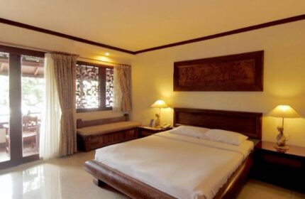 Grand Balisani Suites Hotel room. Gay-friendly hotel with a bed, balcony, and warm lighting. A great choice for gay travel.