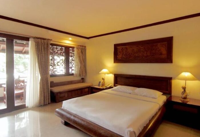 Grand Balisani Suites Hotel room. Gay-friendly hotel with a bed, balcony, and warm lighting. A great choice for gay travel.