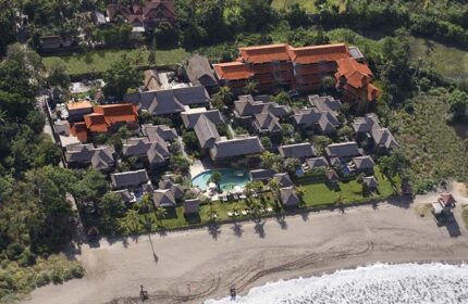 Aerial of Grand Balisani Suites Hotel, a gay-friendly hotel. Beachfront property with pool, bungalows, and lush greenery. Bali travel.