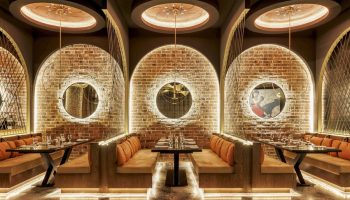 Grand Fiesta Americana Coral Beach Cancun restaurant. Chic interior with brick arches, booths, and circular mirrors. Gay-friendly hotel.