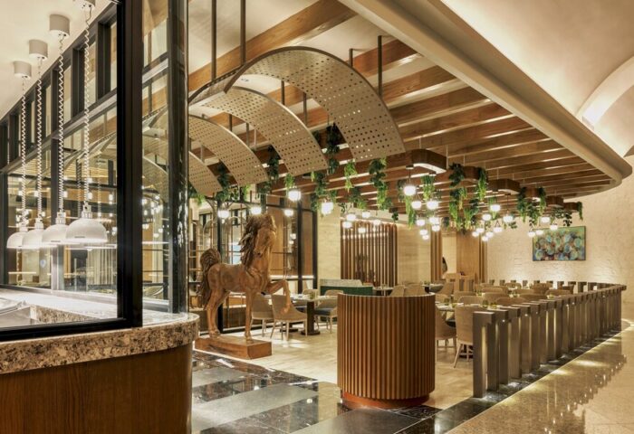 Grand Fiesta Americana Coral Beach Cancun All Inclusive restaurant interior. Wood horse statue, modern lighting, and elegant decor. Gay-friendly hotel.