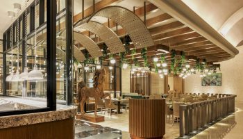 Grand Fiesta Americana Coral Beach Cancun All Inclusive restaurant interior. Wood horse statue, modern lighting, and elegant decor. Gay-friendly hotel.