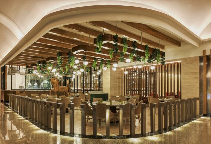 Grand Fiesta Americana Coral Beach Cancun All Inclusive gay-friendly hotel restaurant. Hanging lights and plants above tables, horse statue.