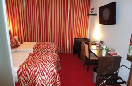 Grand Hotel Dream Main City Center room. Gay-friendly hotel with red striped curtains, zebra print bedding, and desk. Main City Center hotel.