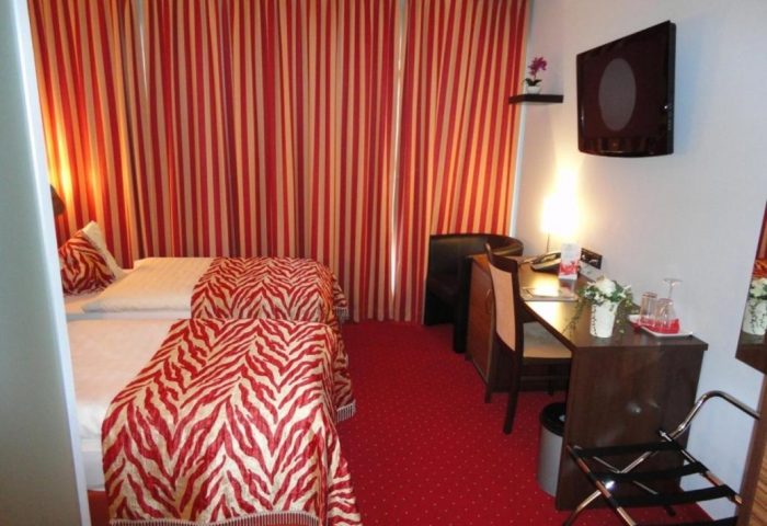 Grand Hotel Dream Main City Center room. Gay-friendly hotel with red striped curtains, zebra print bedding, and desk. Main City Center hotel.