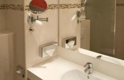 Grand Hotel Dream Main City Center bathroom. Gay-friendly hotel features include a sink, mirror, and toiletries for the modern gay traveler.