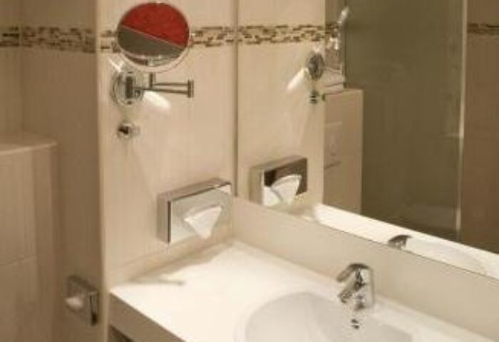 Grand Hotel Dream Main City Center bathroom. Gay-friendly hotel features include a sink, mirror, and toiletries for the modern gay traveler.