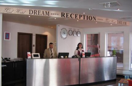 Grand Hotel Dream Main City Center reception desk with staff. Gay-friendly hotel. Clocks showing different time zones.