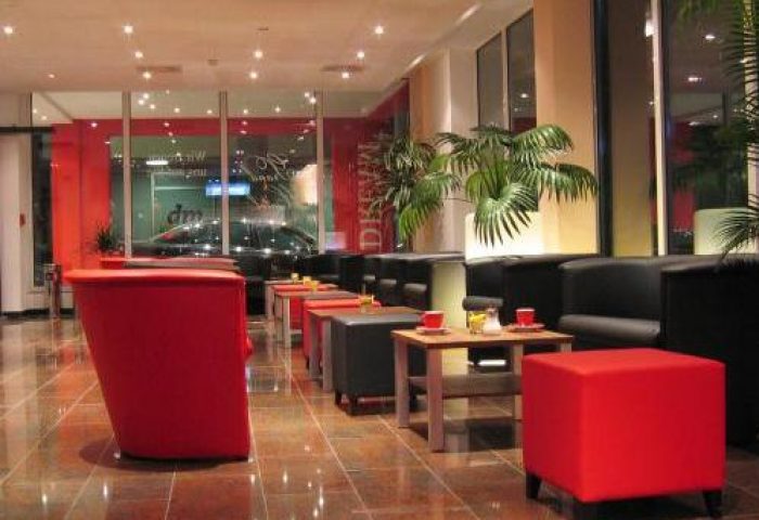 Grand Hotel Dream Main City Center lounge area. Gay-friendly hotel with modern design, red accents, and comfortable seating. Ideal for gay travel.