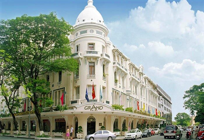 Facade of the Grand Hotel Saigon, a gay-friendly hotel in Ho Chi Minh City, Vietnam. The building is white with a distinctive dome.