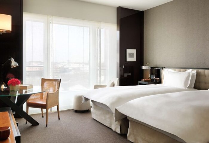 Grand Hyatt Berlin gay-friendly hotel room. Two beds, desk, chair, and large window. Modern design, comfortable for gay travelers in Berlin.