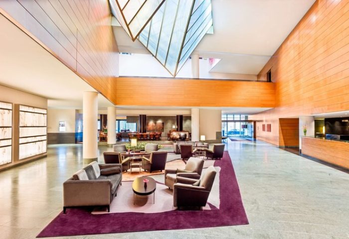 Grand Hyatt Berlin's lobby. Gay-friendly hotel features modern design, seating areas, and a bright, welcoming atmosphere for gay travelers.