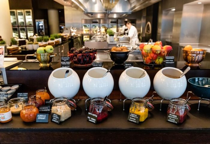 Grand Hyatt Berlin's breakfast buffet with fruits, jams, and compotes. A gay-friendly hotel with a diverse and delicious breakfast selection.