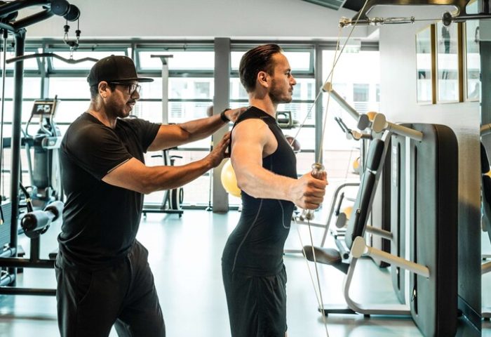 Gay-Friendly Hotel Grand Hyatt Berlin gym. Man works out with trainer. Fitness center at luxury hotel in Berlin. Gay travel advice.
