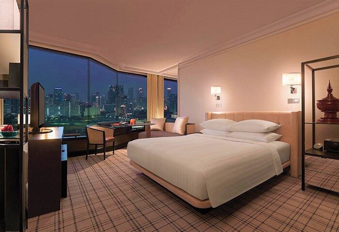 Grand Hyatt Erawan Bangkok room with city view. Gay-friendly hotel with modern design, comfy bed, desk, and Bangkok skyline.