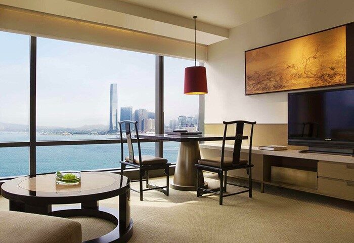 Grand Hyatt Hong Kong room with city view. Gay-friendly hotel featuring modern decor, dining area, and stunning views of Hong Kong's skyline.