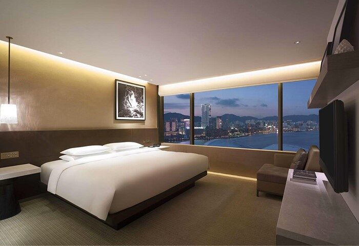Grand Hyatt Hong Kong gay-friendly hotel room. Luxurious bed with city view. Upscale accommodations for LGBTQ+ travelers in Hong Kong.