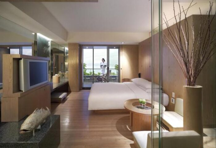 Grand Hyatt Hong Kong gay-friendly hotel room. Modern design, balcony view, wood floors, and neutral tones create a luxurious feel.