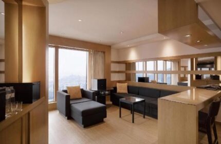 Grand Hyatt Seoul gay-friendly hotel room. Living area with sofa, chaise lounge, and bar. Modern design for gay travelers.