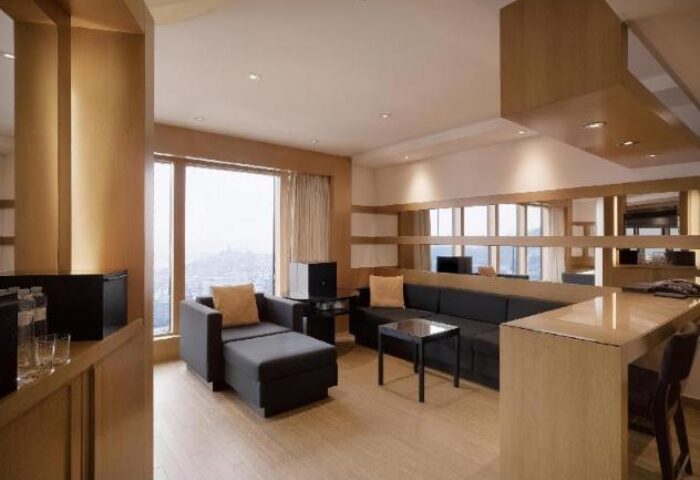 Grand Hyatt Seoul gay-friendly hotel room. Living area with sofa, chaise lounge, and bar. Modern design for gay travelers.